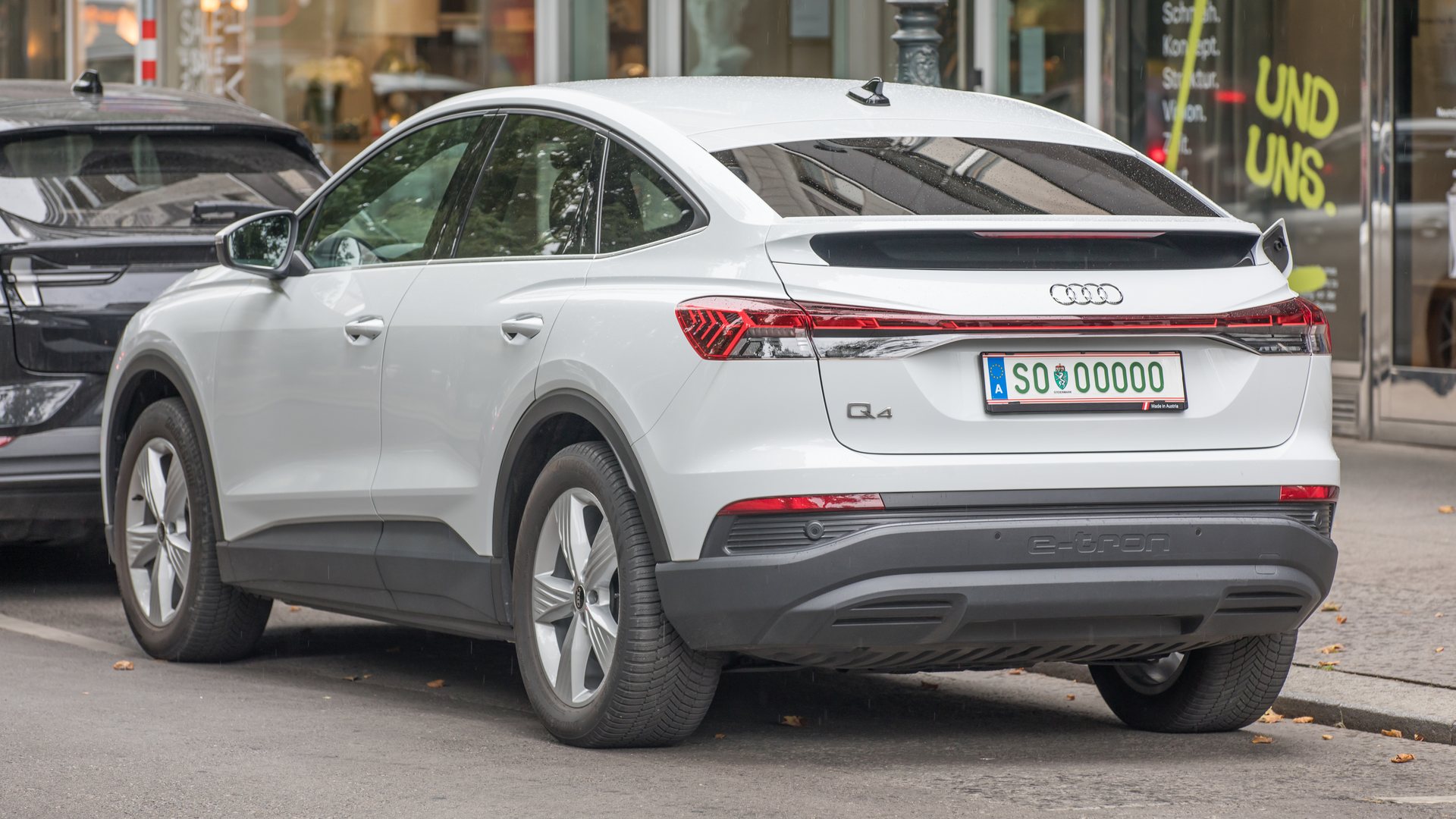 Λευκό Audi Q4 Sportback e-tron σταθμευμένο σε δρόμο, πίσω τρία τέταρτα