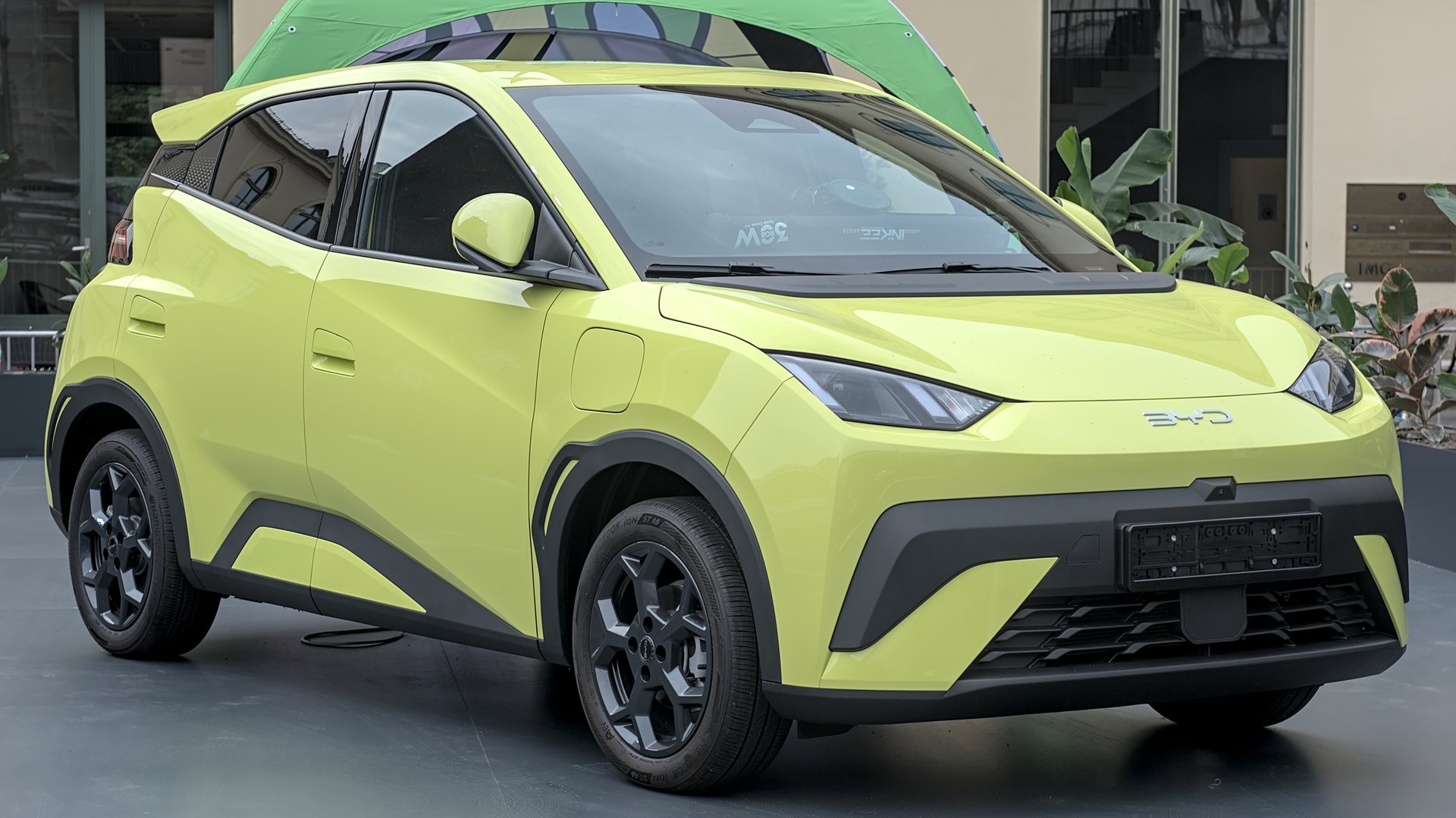 Κιτρινοπράσινο BYD Dolphin Surf σε υπαίθρια έκθεση αυτοκινήτου, μπροστινή τρία τέταρτα