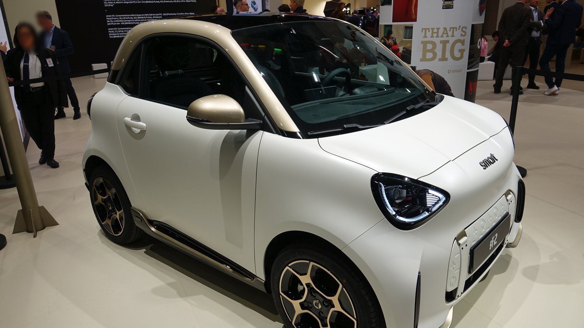 Λευκό ματ smart #2 Couture Edition με χρυσές λεπτομέρειες στο περίπτερο της smart στην έκθεση του Παρισιού, εμπρός τριών τετάρτων λήψη