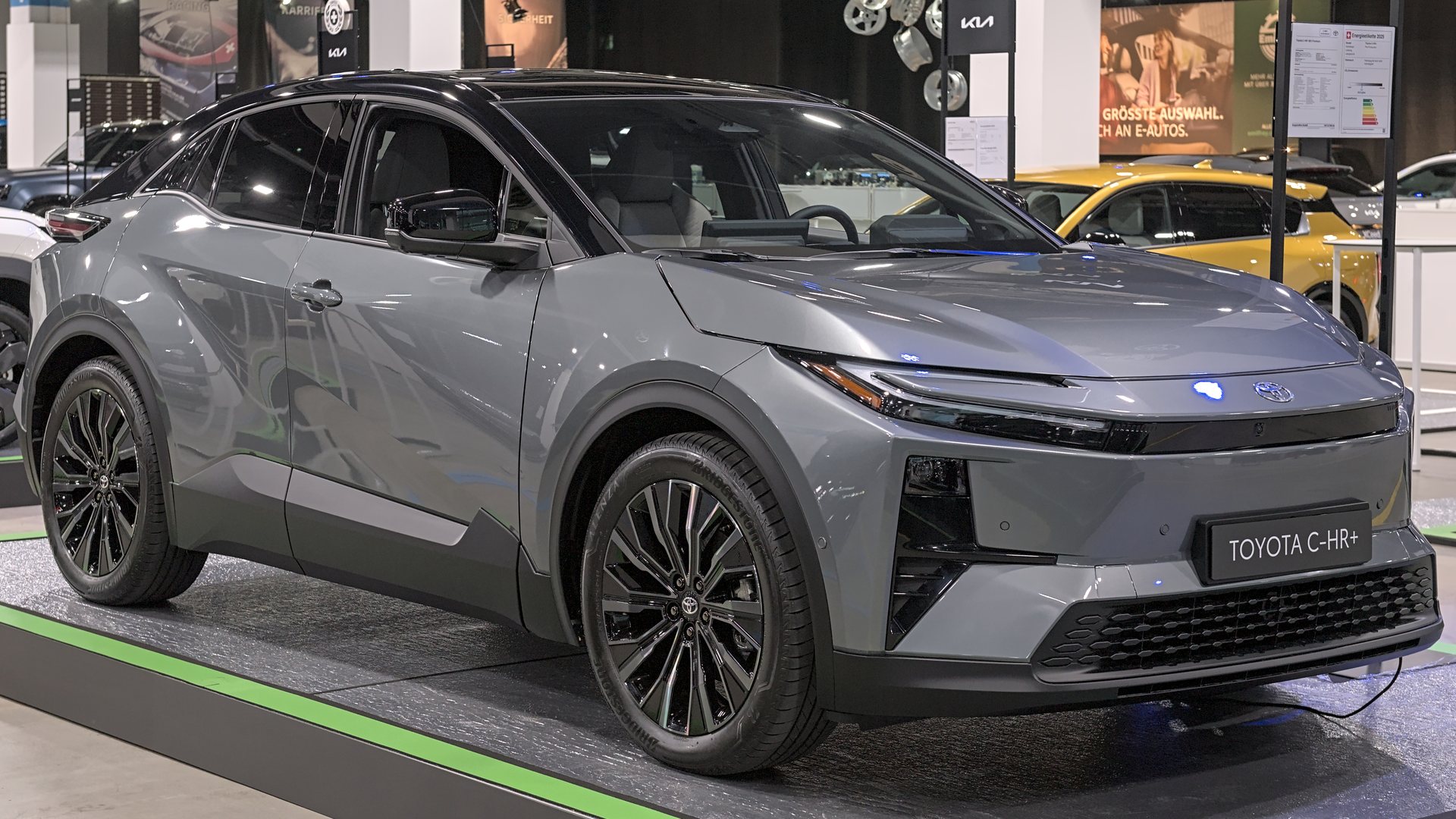 Γκρι Toyota C-HR+ σε περίπτερο έκθεσης αυτοκινήτου, μπροστινή τρία τέταρτα